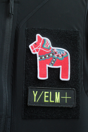 Black jacket with a red and white horse patch and 'Y/ELM+' label on a black background