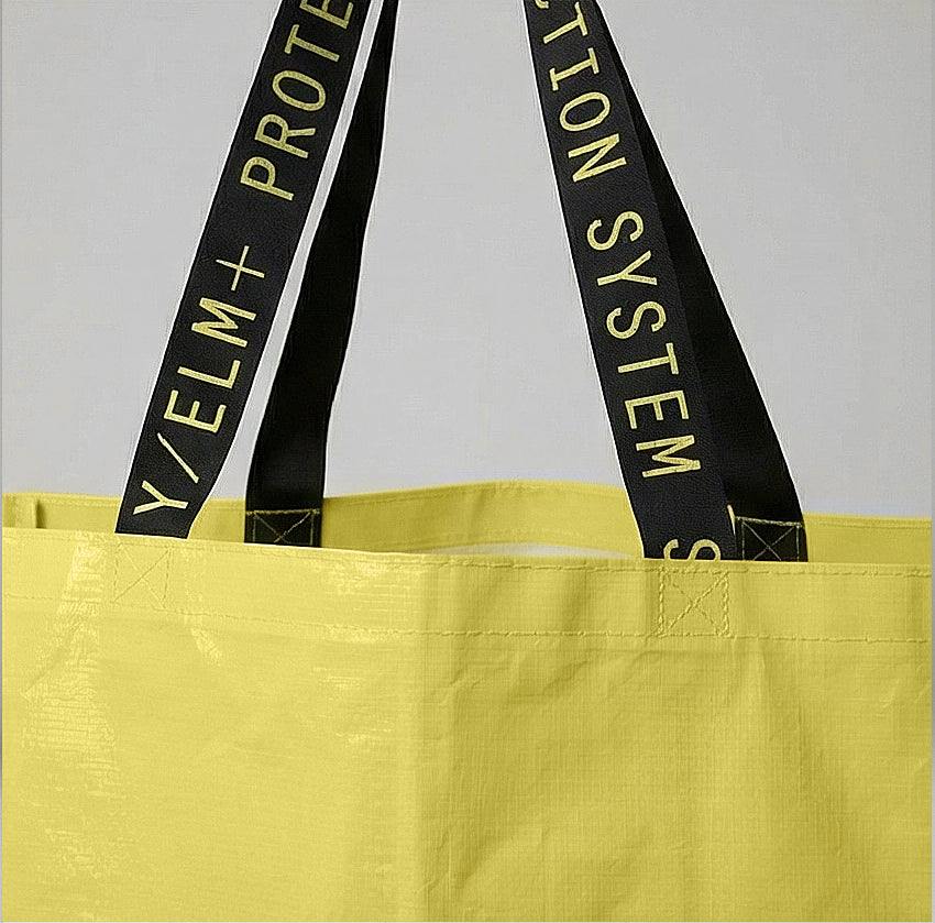 YELM+ haystack tote bag with black straps featuring text on a gray background